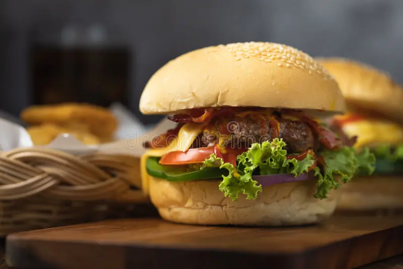 ساندویچ چیکن برگر با نان سیاه، مرغ گریل شده و سبزیجات تازه